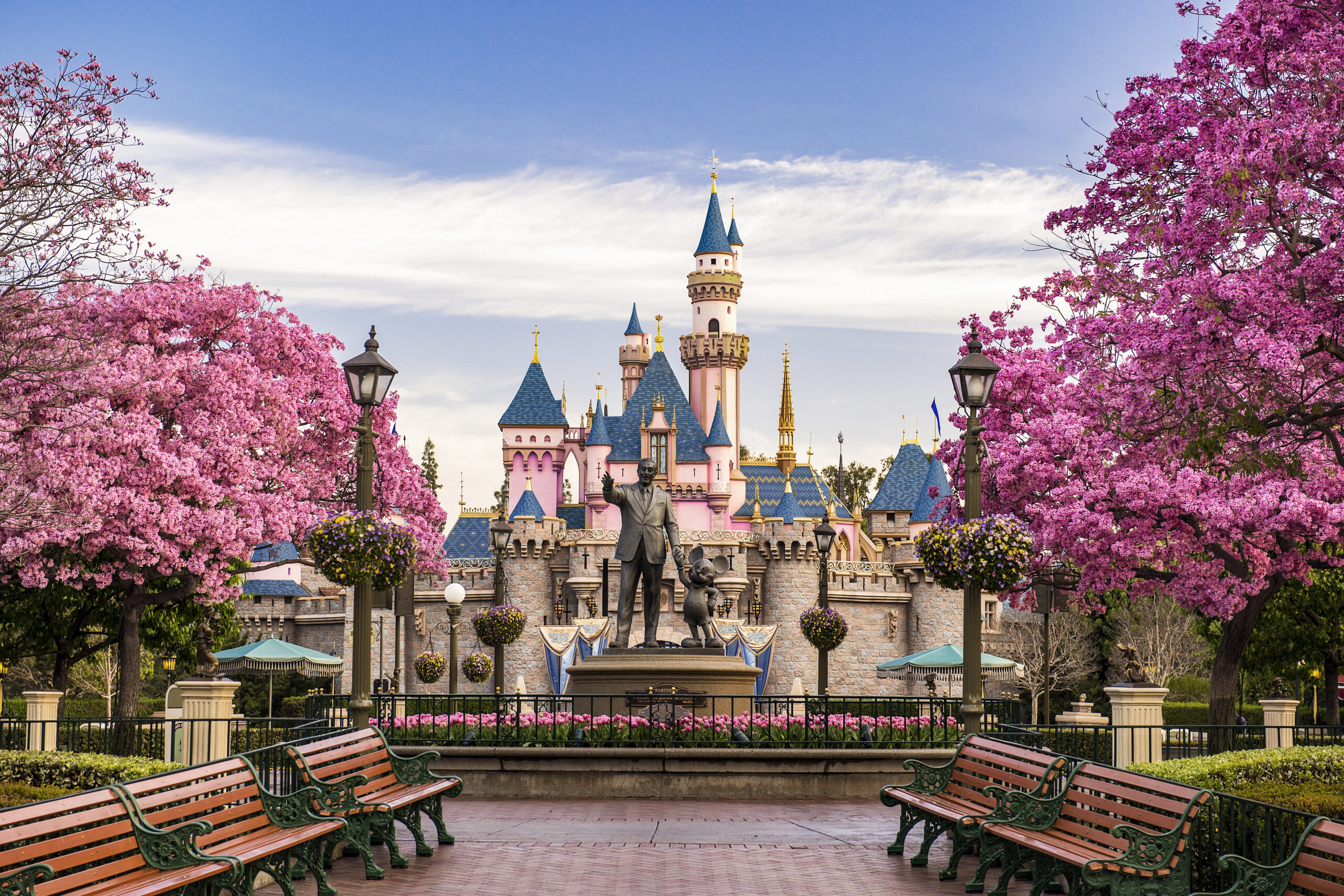 Disneyland castle with a statue of Walt Disney and Mickey Mouse